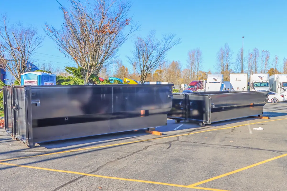 Professional dumpster rental service with roll-off container on residential driveway in Tuscumbia